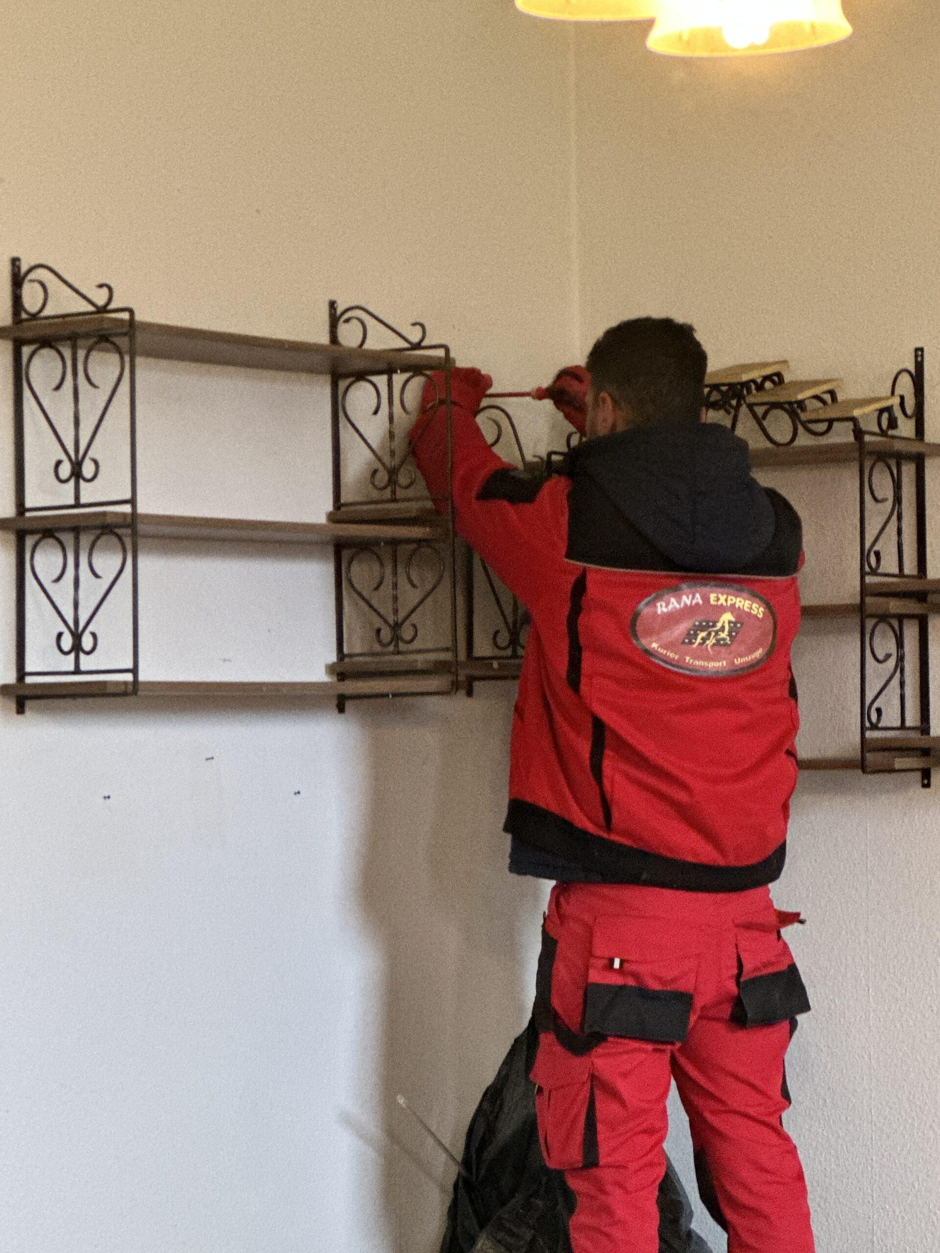 Ein Mitarbeiter montiert ein Wandregal
